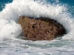 Image of sea crashing over a small rock
